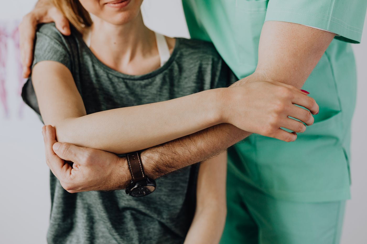 Physiothérapeute mobilisant l'épaule et le coude d'une patiente