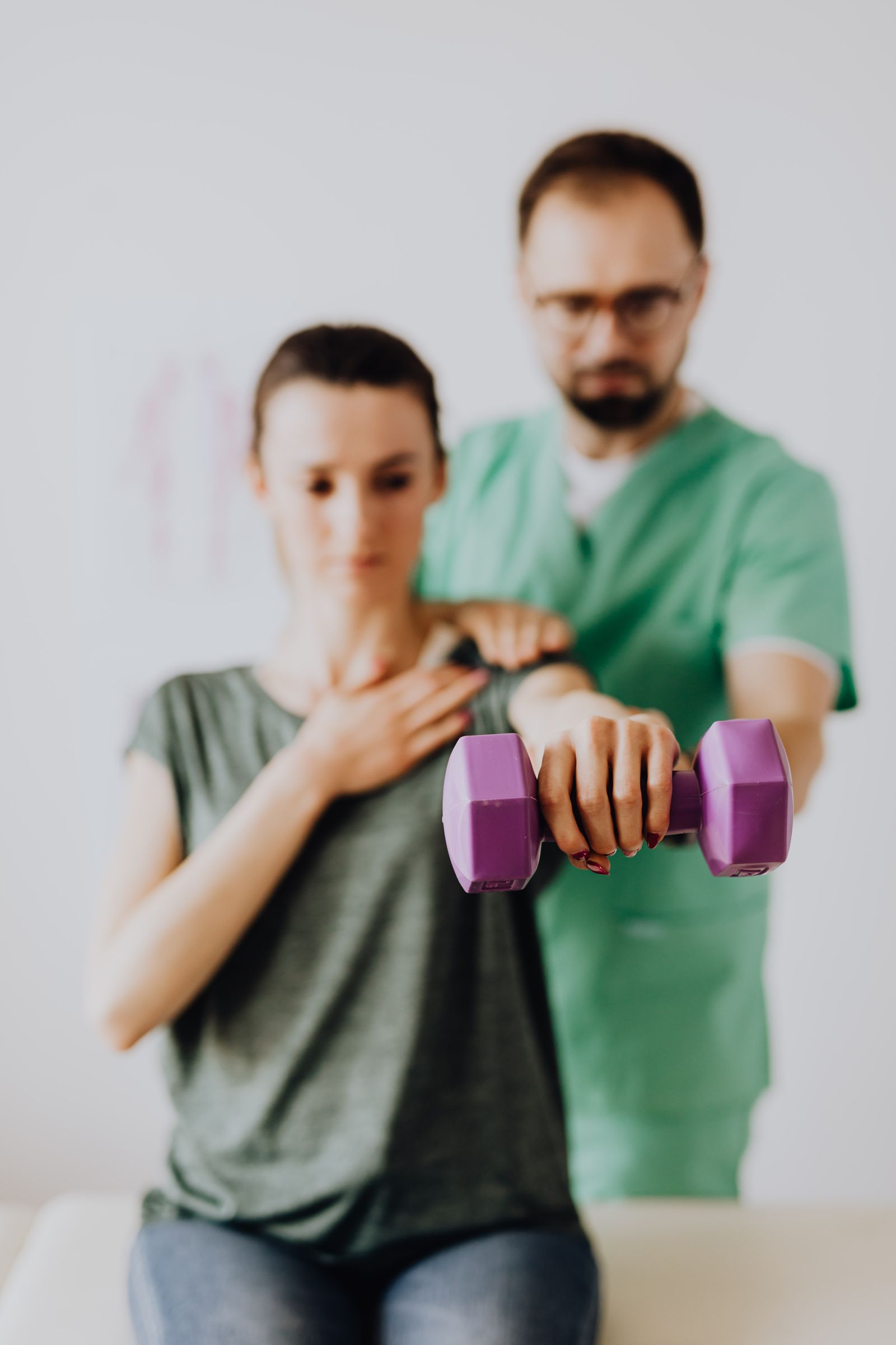 Physiothérapeute accompagnant une patiente lors d'un exercice de renforcement de l'épaule